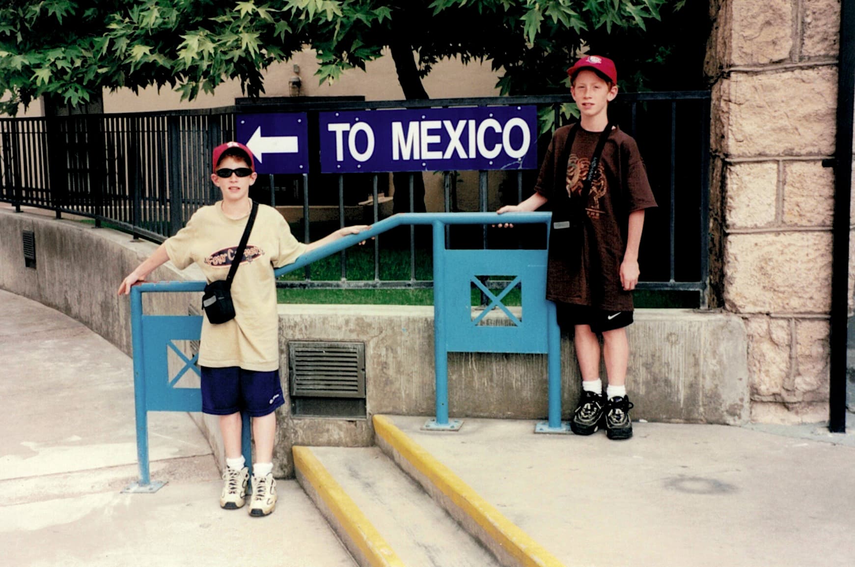 Matt Convente and Mike Convente at the US–Mexico border in Nogales, Arizona posing in front of a sign that says To Mexico with an arrow pointing left.